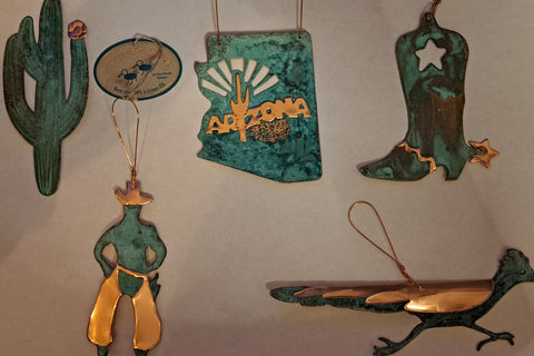 Collection of southwestern-themed decorations including a cactus, cowboy boot, and desert landscape on a white background.